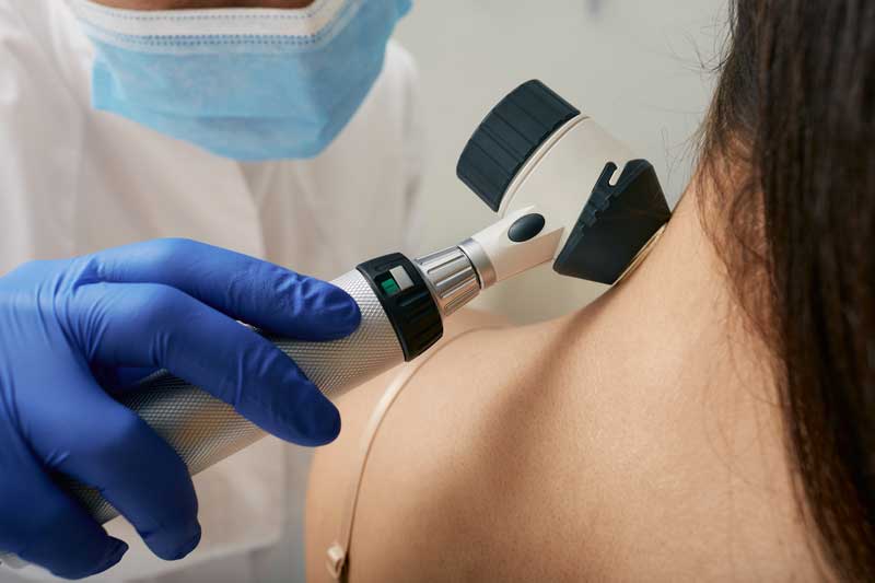Dermatólogo revisando la piel de una paciente